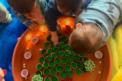 Niños haciendo un árbol de Navidad con cartón y purpurina en la Escuela Infantil Mar de Soles
