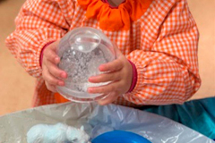 Niña jugando con una bola de cristal con purpurina en la Escuela Infantil Mar de Soles